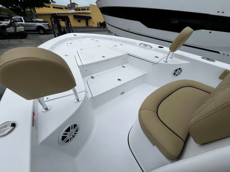 Slide: The Image of 2024 Sportsman Masters 227 Bay Boat interior with tan seating and storage compartments. - 18