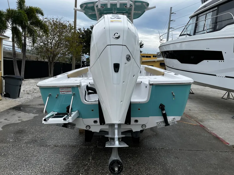 Slide: The Image of 2024 Sportsman Masters 227 Bay Boat, rear view, docked, turquoise and white hull. - 4