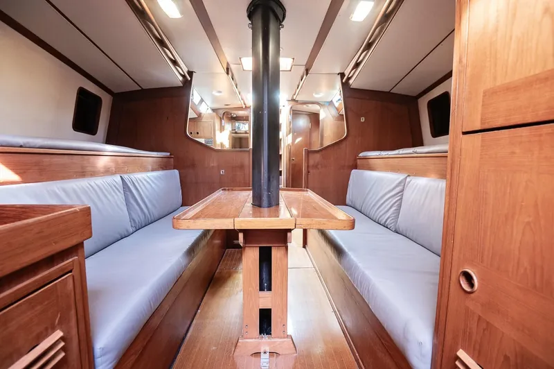 Slide: The Image of Interior of a 1977 Baltic 42 sailboat with wooden furnishings and blue seating. - 11