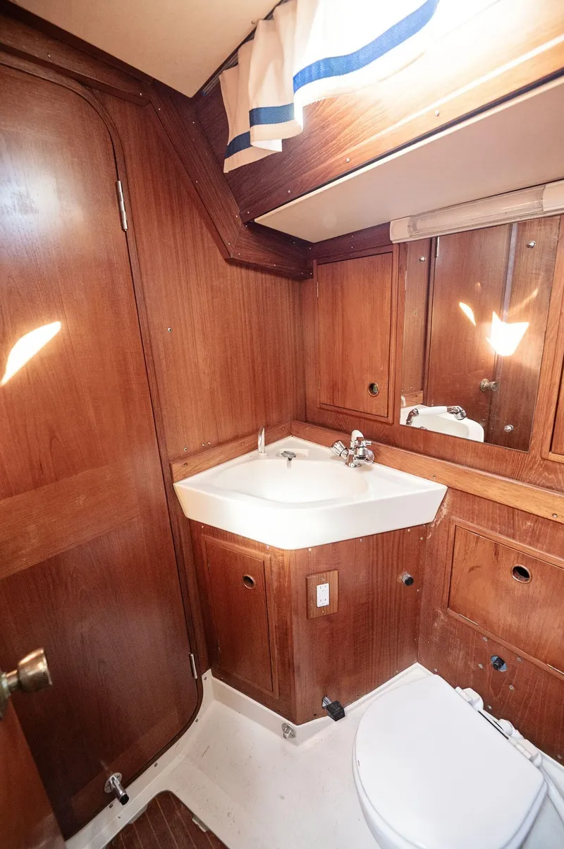 Slide: The Image of 1977 Baltic 42 yacht bathroom with wooden cabinetry and white fixtures. - 14