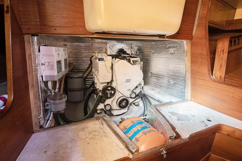 Slide: The Image of Engine compartment of a 1977 Baltic 42 sailboat, featuring mechanical components and insulation. - 15
