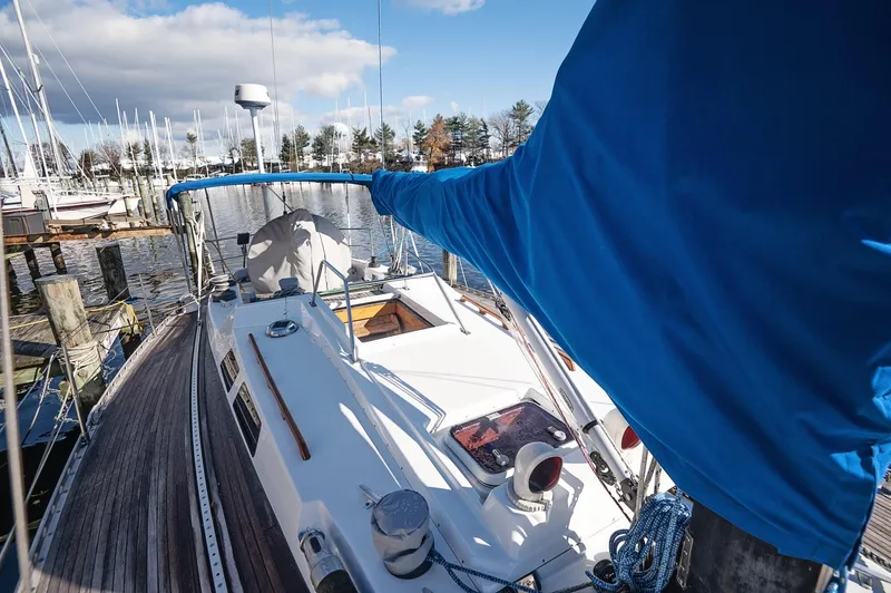 Slide: The Image of Sailboat docked at marina, Baltic 42 model, 1977, with blue cover and clear sky. - 21