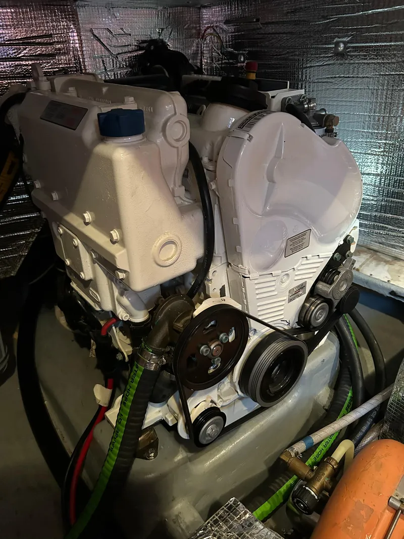 Slide: The Image of Engine compartment of a 1977 Baltic 42 sailboat, featuring a well-maintained marine engine. - 32