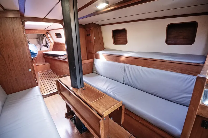 Slide: The Image of Interior of a 1977 Baltic 42 sailboat with wooden furnishings and gray seating. - 7