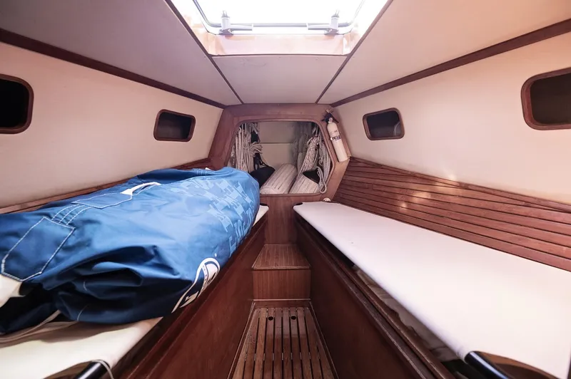 Slide: The Image of Cozy cabin interior of a 1977 Baltic 42 sailboat with wooden finishes and twin berths. - 8