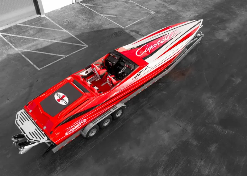 Slide: The Image of 2025 Cigarette 42X powerboat in red and white, parked on a trailer. - 19
