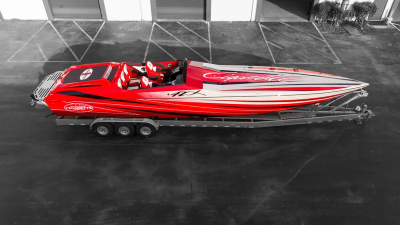 Slide: The Image of 2025 Cigarette 42X speedboat in red and white on a trailer. - 25