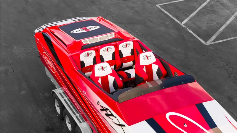 Slide: The Image of 2025 Cigarette 42X speedboat with red and white design, parked on asphalt. - 29