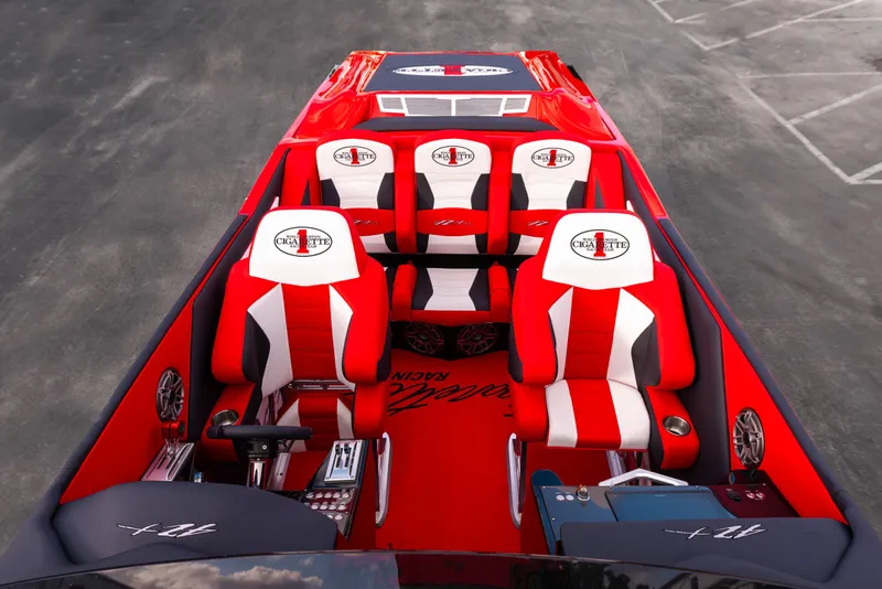 Slide: The Image of 2025 Cigarette 42X boat interior with red and white seats, steering wheel, and controls. - 43