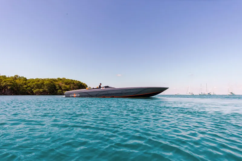 Slide: The Image of 2025 Cigarette 515 speedboat cruising on clear blue water near a lush green shoreline. - 39