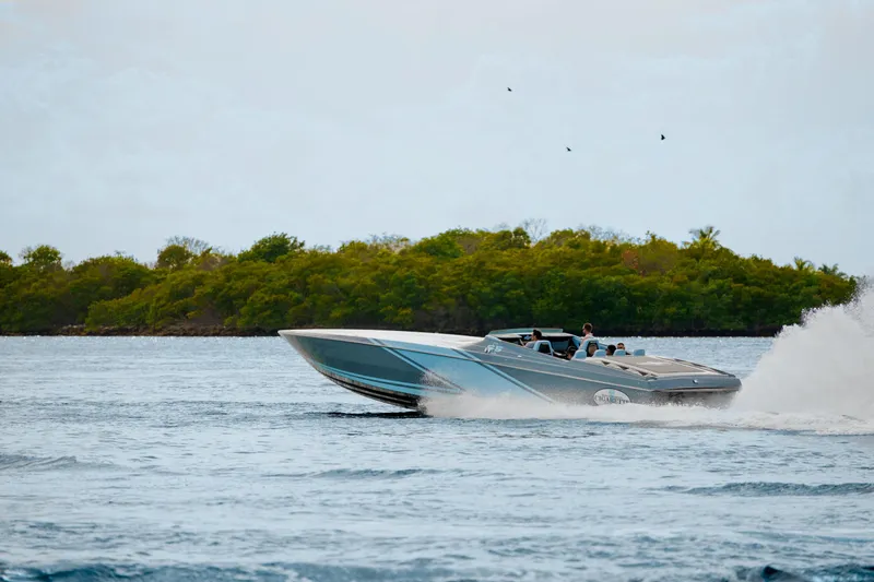 Slide: The Image of 2025 Cigarette 515 speedboat cruising on open water near lush green island. - 47