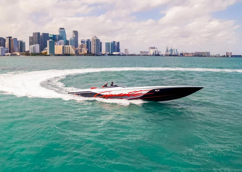 Slide: The Image of Cigarette 515 speedboat cruising in turquoise waters near a city skyline, 2025 model. - 5