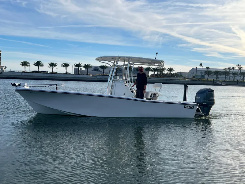 Slide: The Image of 2024 Deno 2400 CC boat on calm water with a person standing onboard. - 0