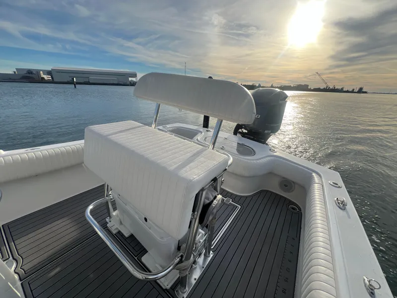 Slide: The Image of 2024 Deno 2400 CC boat with white seating, docked on calm waters at sunset. - 10
