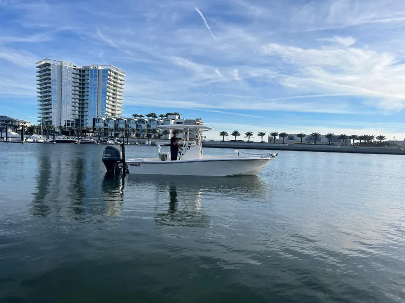 Slide: The Image of 2024 Deno 2400 CC boat on calm water near modern waterfront buildings. - 11