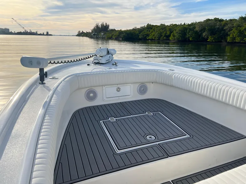 Slide: The Image of 2024 Deno 2400 CC boat on calm water with scenic background. - 2