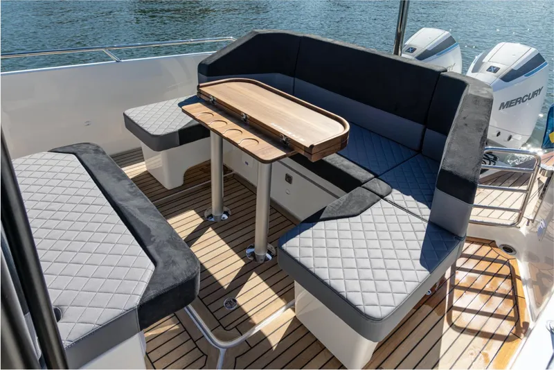 Slide: The Image of Luxurious seating area on the 2024 Nimbus T9 boat with quilted cushions and wooden table. - 5