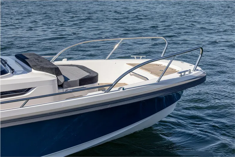 Slide: The Image of 2024 Nimbus T9 boat bow on water, featuring sleek design and stainless steel railings. - 7