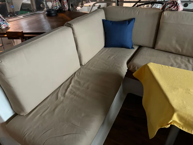 Slide: The Image of Interior seating area of a 1992 Bayliner 3288 Motoryacht with beige cushions and a blue pillow. - 16