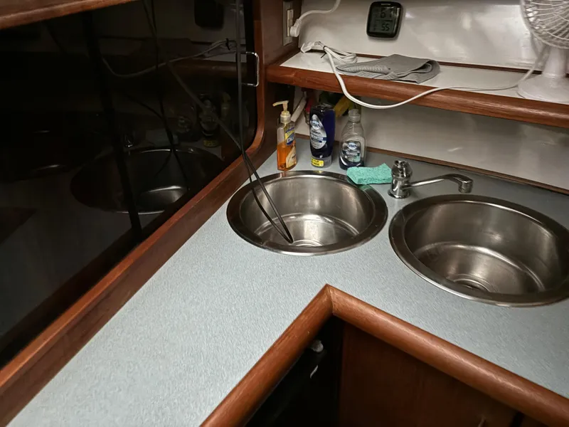 Slide: The Image of 1992 Bayliner 3288 Motoryacht kitchen with dual sinks and cleaning supplies. - 20