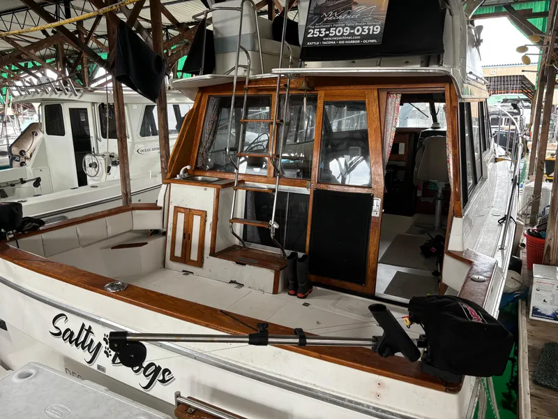 Slide: The Image of 1992 Bayliner 3288 Motoryacht docked, featuring wooden trim and spacious deck area. - 4