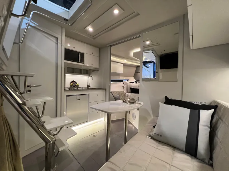 Slide: The Image of 2024 Evolve 360HT yacht interior with modern kitchen, dining area, and cozy seating. - 15