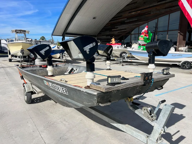 Slide: The Image of 1995 WeldBilt 15 boat with mounted lights on a trailer in a marina. - 1