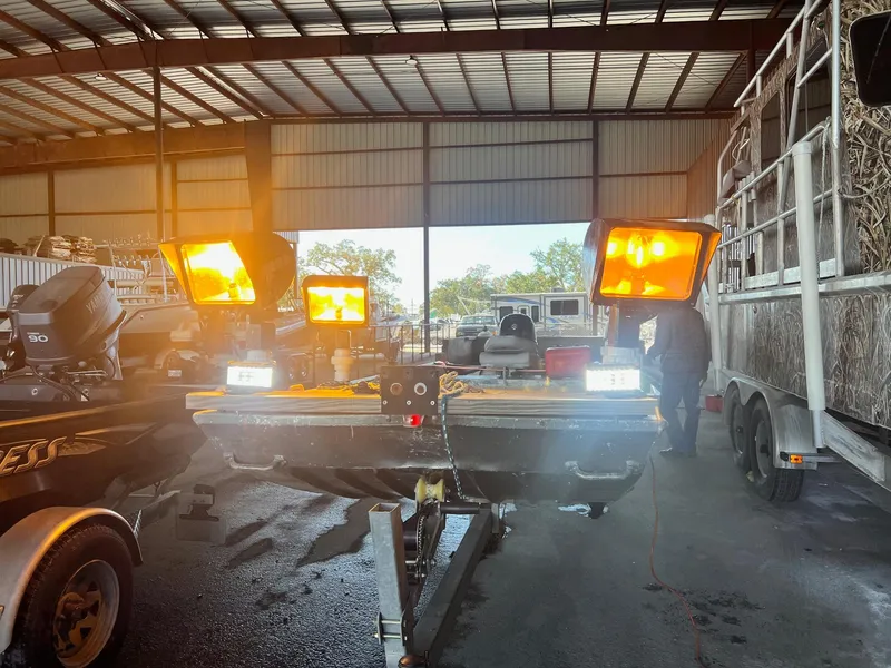 Slide: The Image of 1995 WeldBilt 15 boat with bright lights in a warehouse. - 10