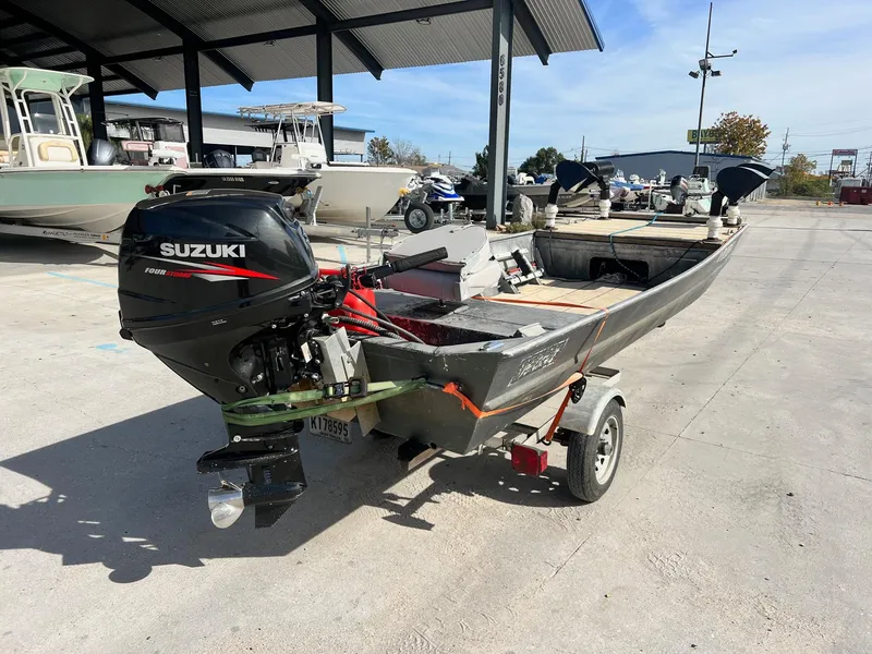 Slide: The Image of 1995 WeldBilt 15 boat with Suzuki outboard motor on trailer in marina. - 2