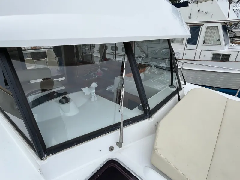 Slide: The Image of 2013 Beneteau Swift Trawler 34, exterior view with windows and seating area. - 25