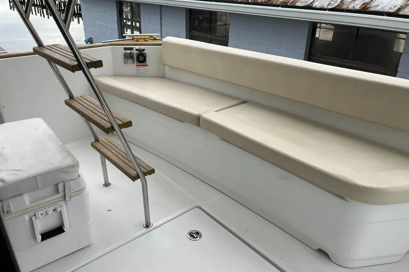 Slide: The Image of 2013 Beneteau Swift Trawler 34 deck with cushioned seating and wooden steps. - 47
