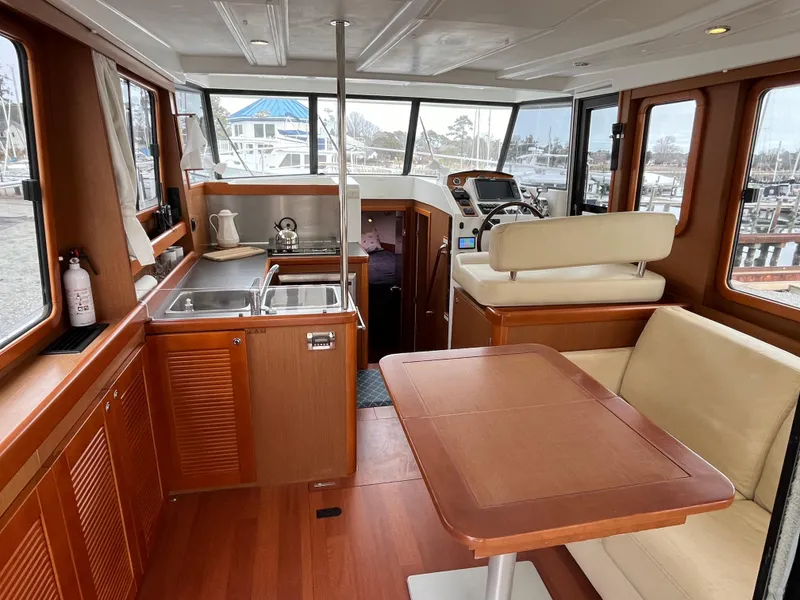 Slide: The Image of 2013 Beneteau Swift Trawler 34 interior with kitchen, dining area, and helm station. - 48