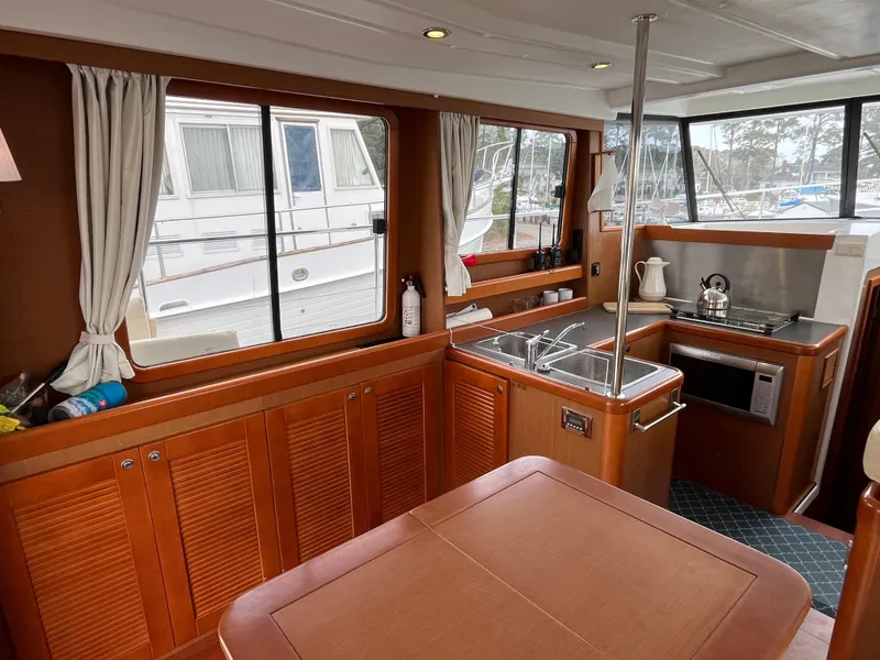 Slide: The Image of Interior of 2013 Beneteau Swift Trawler 34, featuring a cozy kitchen and dining area. - 49