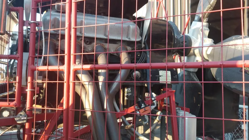 Slide: The Image of Close-up of a 2010 Airboat 18x8 engine behind a red protective cage. - 2
