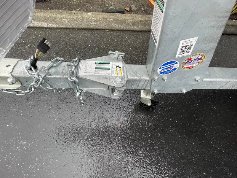 Slide: The Image of Trailer hitch of a 2024 Crestliner 1650 Fish Hawk SC on wet pavement. - 12