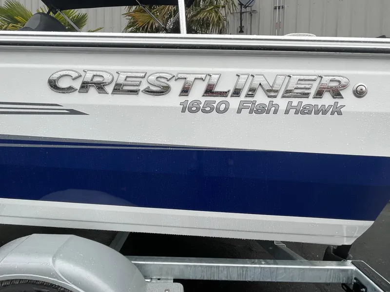 Slide: The Image of 2024 Crestliner 1650 Fish Hawk SC boat side view with logo and trailer. - 4