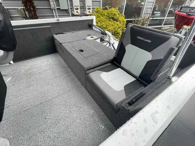 Slide: The Image of 2024 Crestliner 1650 Fish Hawk SC interior with gray seating and storage compartments. - 6