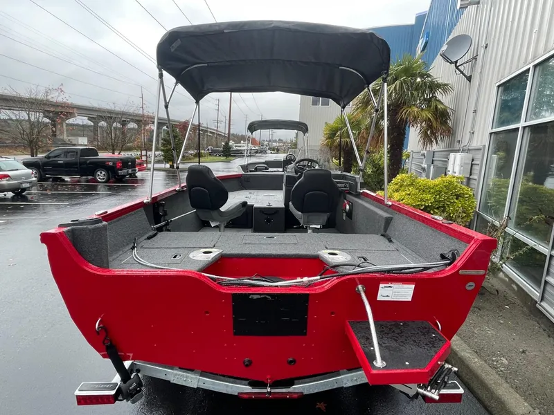 Slide: The Image of 2021 Crestliner 1650 Fish Hawk SC, red boat with canopy, parked outdoors. - 4