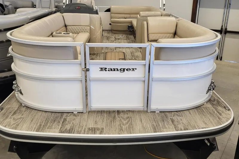 Slide: The Image of 2024 Ranger Reata 223C pontoon boat with beige seating and wood-style flooring. - 1
