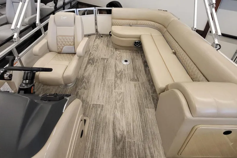 Slide: The Image of 2024 Ranger Reata 223C boat interior with beige seating and wood-patterned flooring. - 4