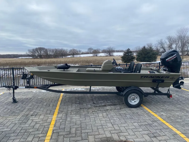 The Image of 2024 Tracker Grizzly 1754 SC boat on a trailer in a parking lot. - 0