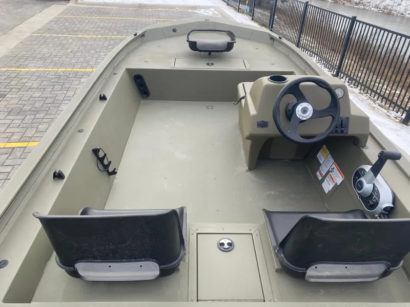 Slide: The Image of 2024 Tracker Grizzly 1754 SC boat interior with steering console and seating. - 2
