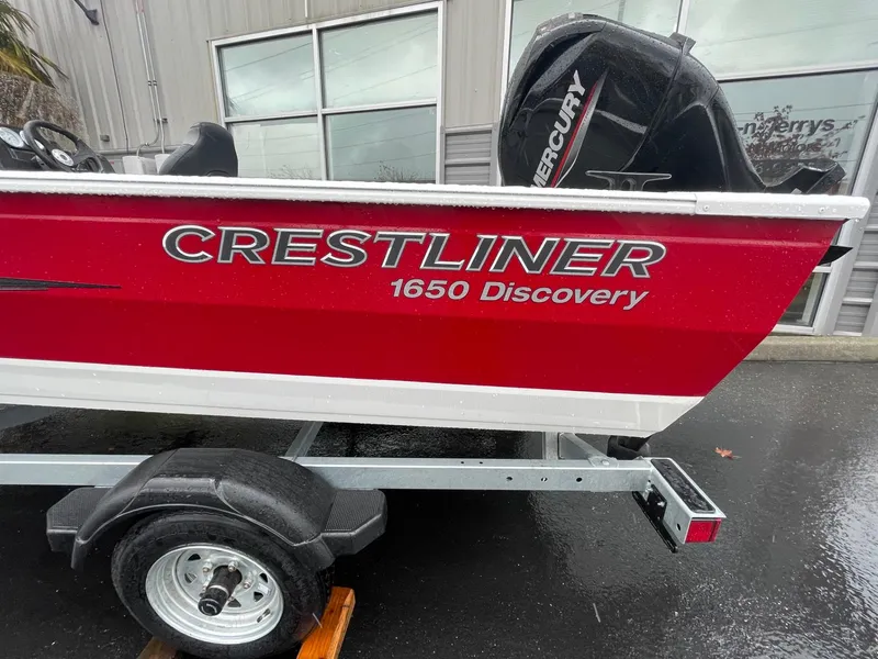 Slide: The Image of 2024 Crestliner 1650 Discovery SC boat on trailer, red and white exterior. - 4