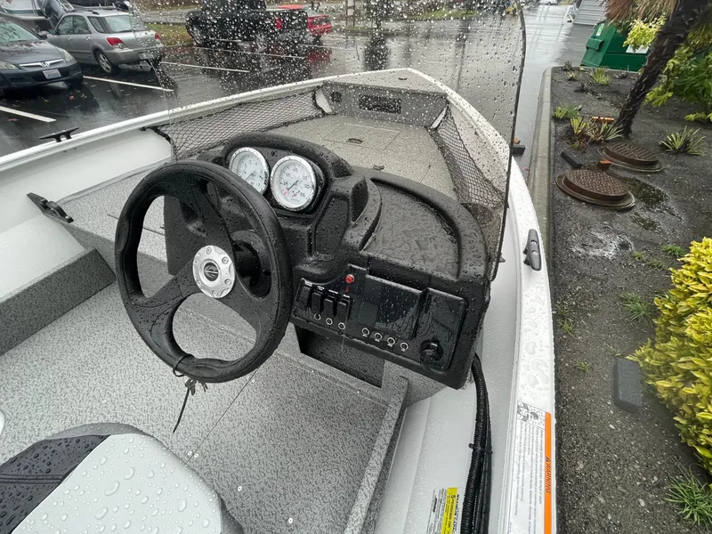 Slide: The Image of 2024 Crestliner 1650 Discovery SC boat dashboard in rainy parking lot. - 6