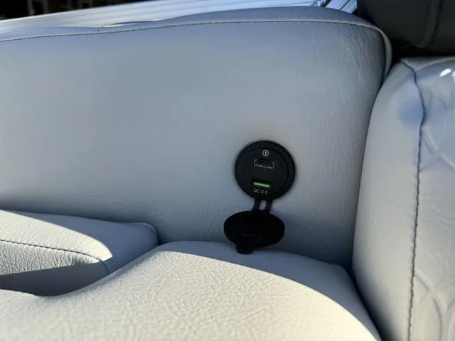 Slide: The Image of 2024 Avalon LSZ Versatile Rear Lounger 23 FT with USB charging port on white leather seat. - 17