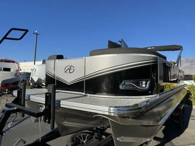 Slide: The Image of 2024 Avalon LSZ Versatile Rear Lounger 23 FT pontoon boat, sleek design, parked outdoors. - 3