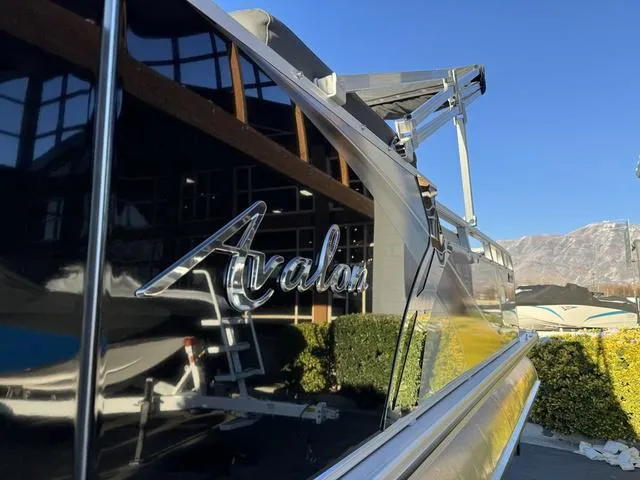 Slide: The Image of 2024 Avalon LSZ Versatile Rear Lounger 23 FT boat, shiny exterior, outdoor setting. - 4