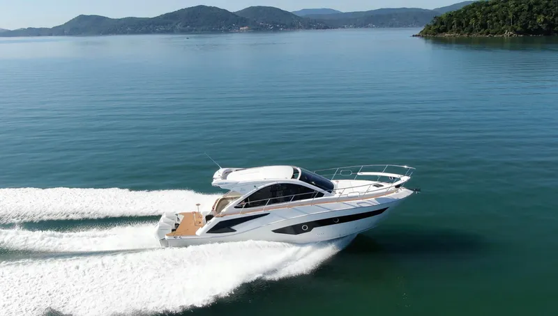 Slide: The Image of 2024 Evolve 400HT yacht cruising on a serene lake with mountainous backdrop. - 11