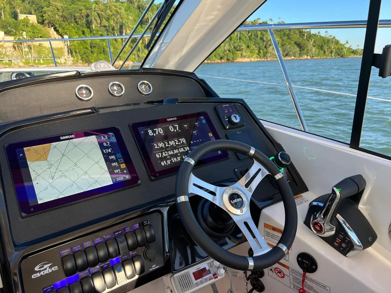 Slide: The Image of 2024 Evolve 400HT boat dashboard with navigation screens and steering wheel. - 19
