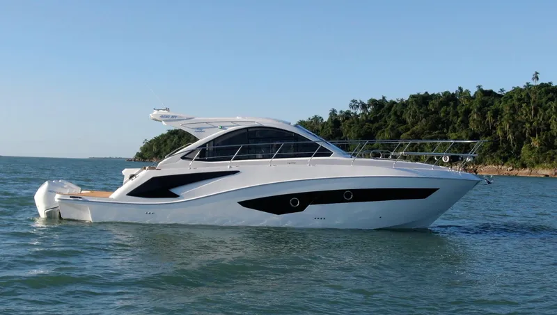 Slide: The Image of 2024 Evolve 400HT luxury yacht cruising on the ocean near a forested coastline. - 2